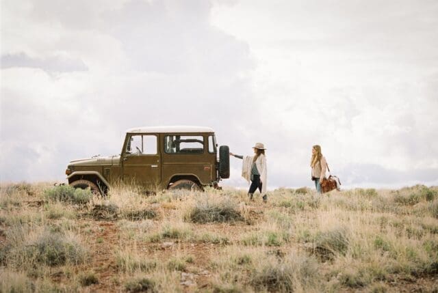 two-women-by-a-jeep-in-open-space-loading-up-for-a road trip