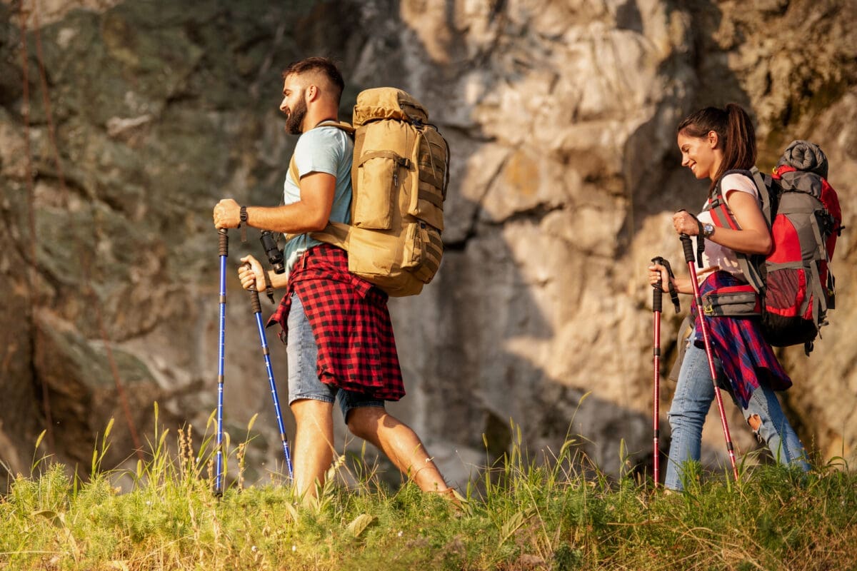 Hikers with backpacks and hiking sticks walking through forest together-Backpacking in Australia