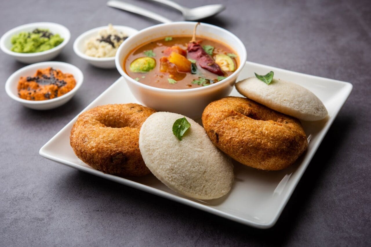 A plateful of Idli Vada sambar with an accompanying bowl of soup