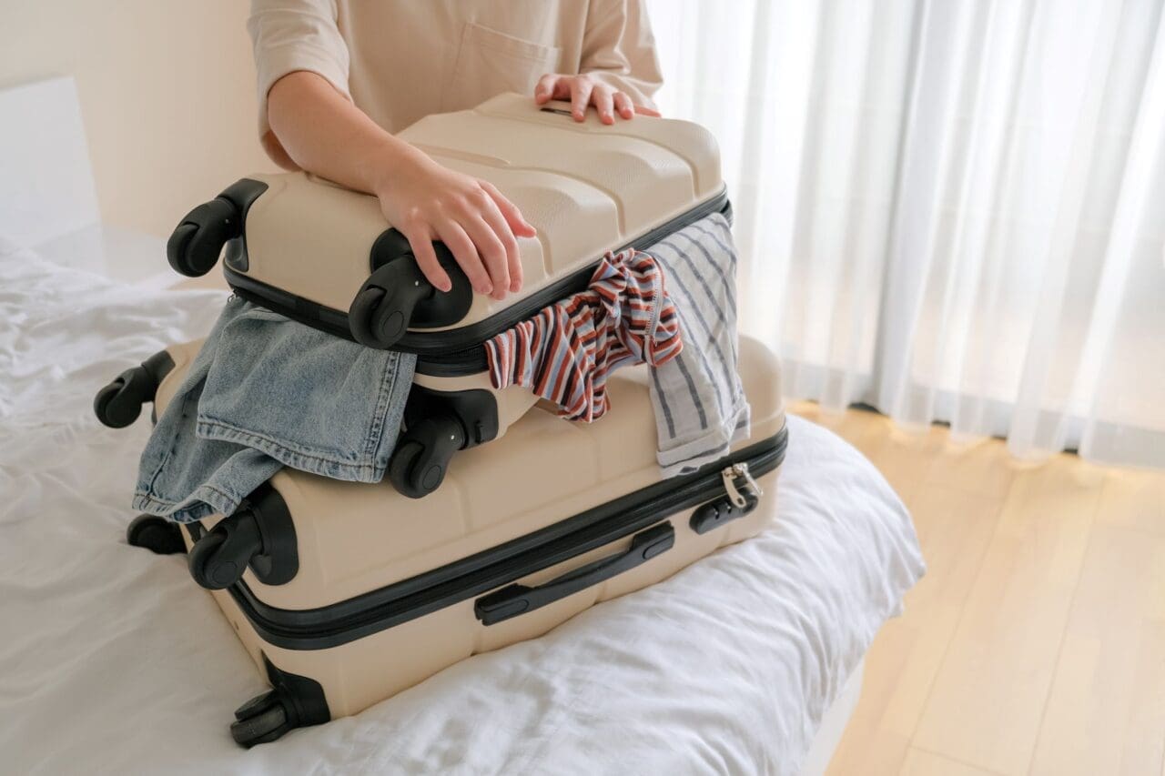 Girl traveler packing luggage in suitcase