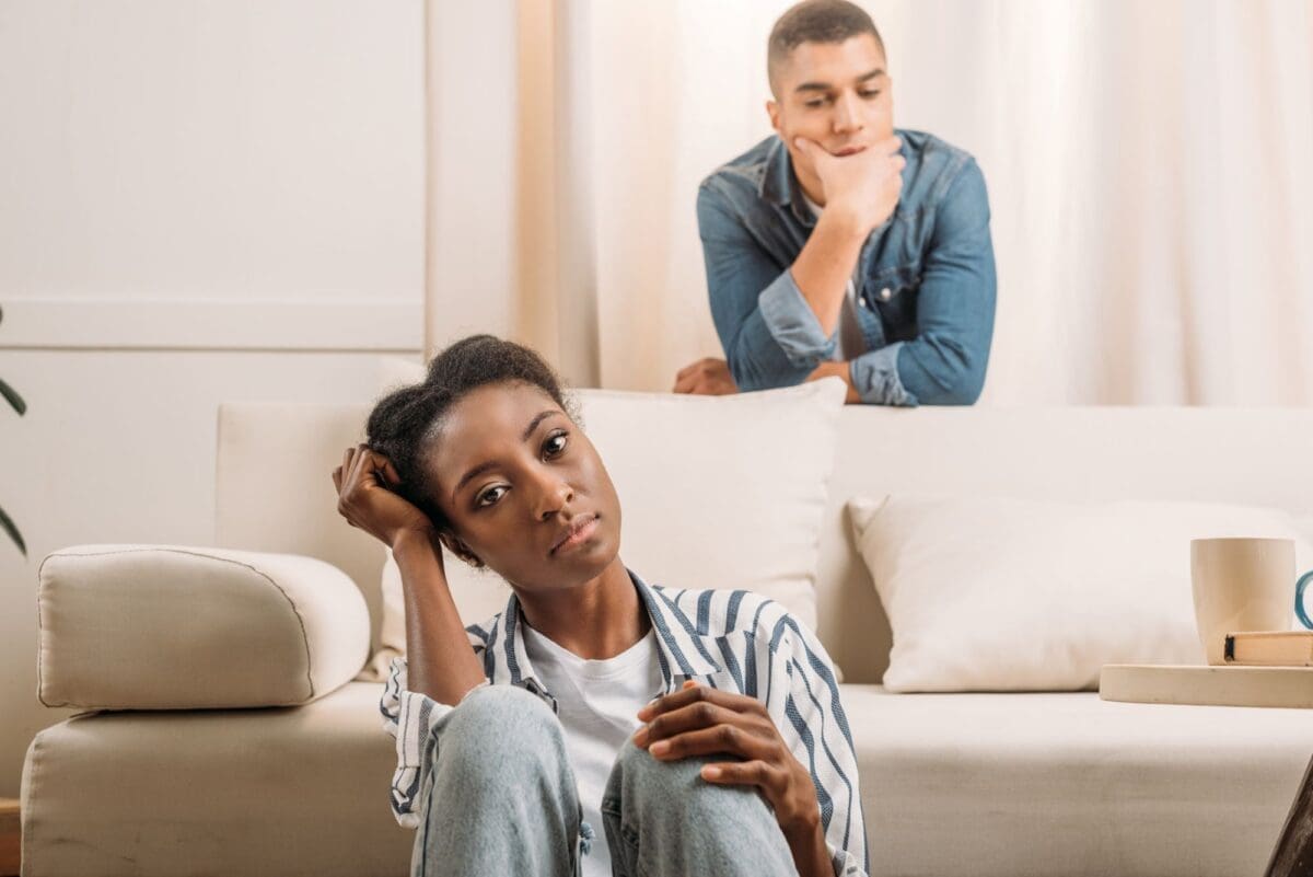 front view of frustrated African American couple beside couch at home- Boundaries You Need To Set